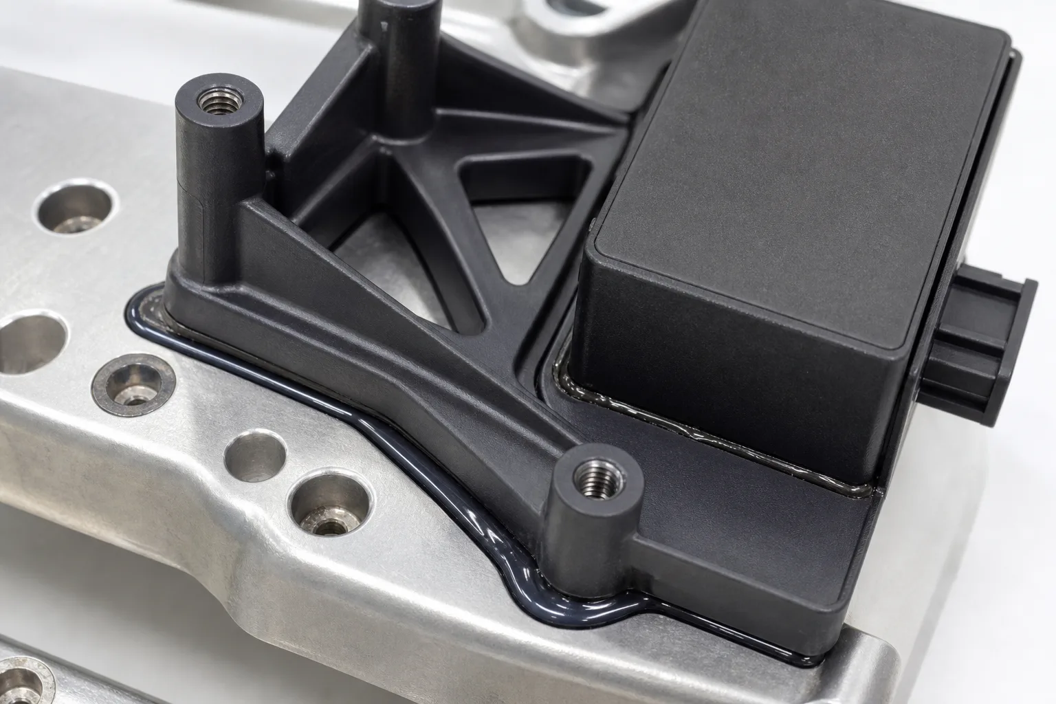 This image highlights vibration resistant bonding for radar brackets, focusing on adhesive application quality critical for automotive reliability.