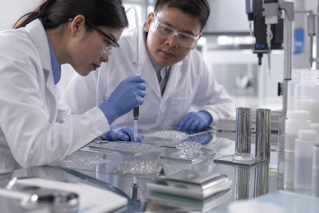 Laboratory evaluation of clear silicone samples on transparent and metal substrates for cure and clarity checks.